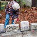 Marianne Burton of the Michael Trebert Chapter of the Daughters of the American Revolution, sprays a solution called D/2 (TM) on the headstone of Joseph Cosentine as part of an effort to restore and preserve the headstones of Pioneer Memorial Park in Sequim, which used to be a cemetery before flooding from Bell Creek caused it to close in 1919. Most of the graves and headstones were removed but some headstones remain in a corner of the park. Sequim Gazette photo by Emily Matthiessen