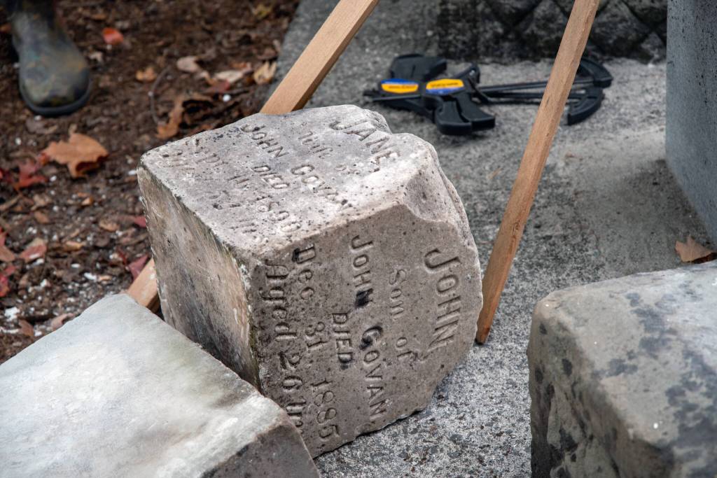 The joint headstone of John and Jane Govan, son and wife of John Govan, waits to be fitted to its proper base after being scraped of old white mortar by volunteers in Sequims Pioneer Memorial Park. This family did a lot with engineering roads, said Priscilla Hudson, historian of the Sequim Prairie Garden Club and Pioneer Memorial Park. The Govans were well-established in the public sector; they built roads and held important jobs in transportation. Jane and John were born in Scotland, as was their first son, John. They waited at a farm that had been in the family for 200 years until the baby was old enough to take the ocean voyage to the USA. They settled in Sequim after spending 3 years in Oregon. The couple had 8-10 children, but after their eldest, John, was killed at 25-years-old on New Years Eve, 1885 in Dungeness Bay, Hudson said Jane was overcome with grief, and took her own life in 1890. Sequim Gazette photo by Emily Matthiessen