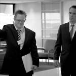 In the film The Interviewer, James Dexter (portrayed by Gerard Odwyer) ushers an unsure Thomas Howell (portrayed by Winston Cooper) into a meeting room to conduct a job interview. Screenshot courtesy of Sproutflix