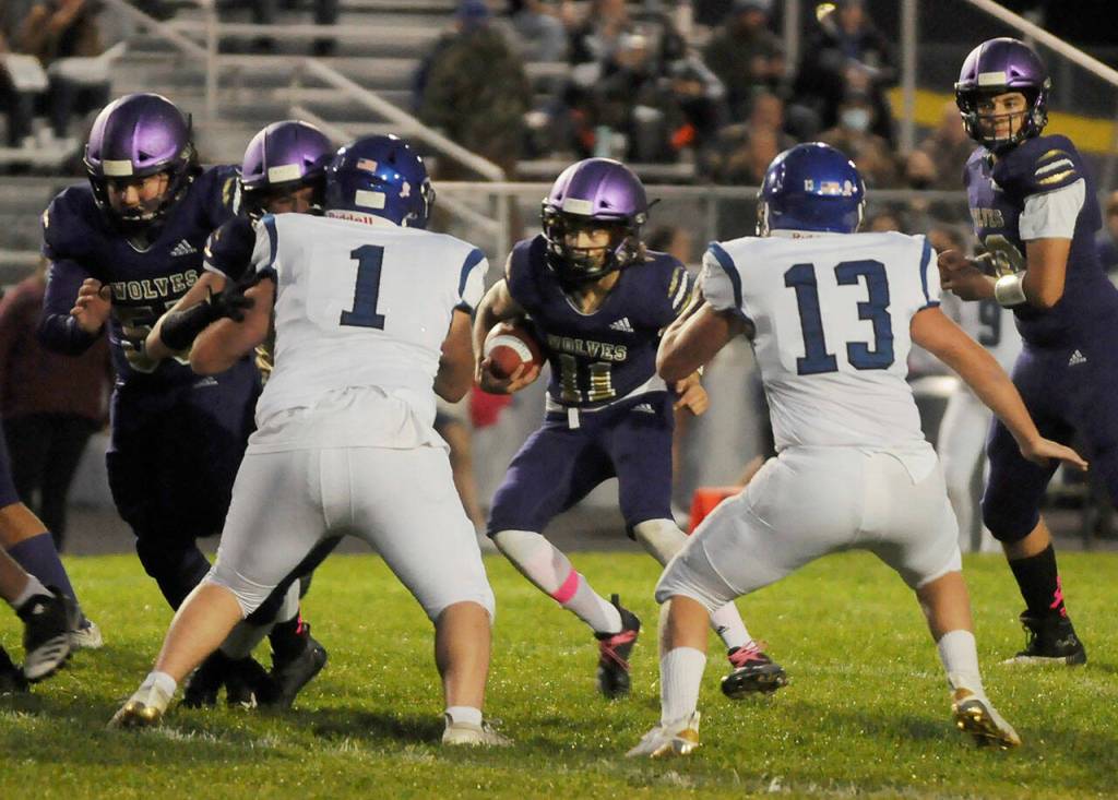 Sequims Aiden Gockerell, center, looks for running room in the Wolves 29-28 win over North Mason on Oct. 16. Sequim Gazette photo by Michael Dashiell