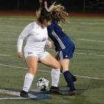 Sequims Samantha Gonzalez, left, gets tangled up with Bainbridges Gabby Weis at midfield in an Olympic League game on Oct. 14. Bainbridge edged Sequim, 1-0. Photo by Mark Krulish/Kitsap News Group