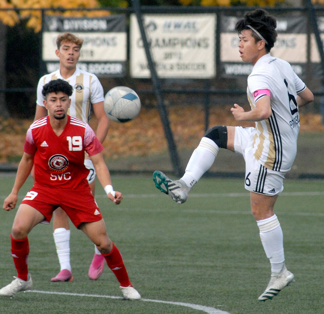 Peninsulas Jeong Hyun Kang, right, gets in a high kick as Skagit Valleys Sergio Garduno Mendez, left, and teammate Christopher Dominguez look on during an Oct. 20 match in Port Angeles. Photo by Keith Thorpe/Olympic Peninsula News Group