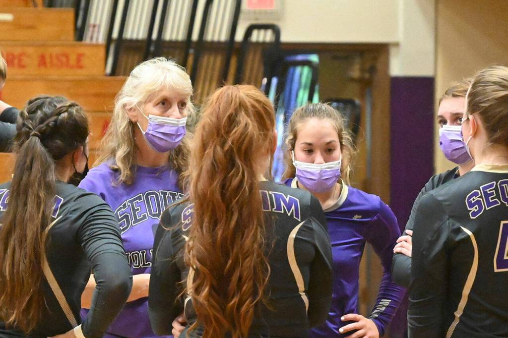 With players donning masks during matches during the 2021 season, SHS head coach Jennie Webber Heilman talks with them during a timeout. Sequim Gazette file photo by Michael Dashiell