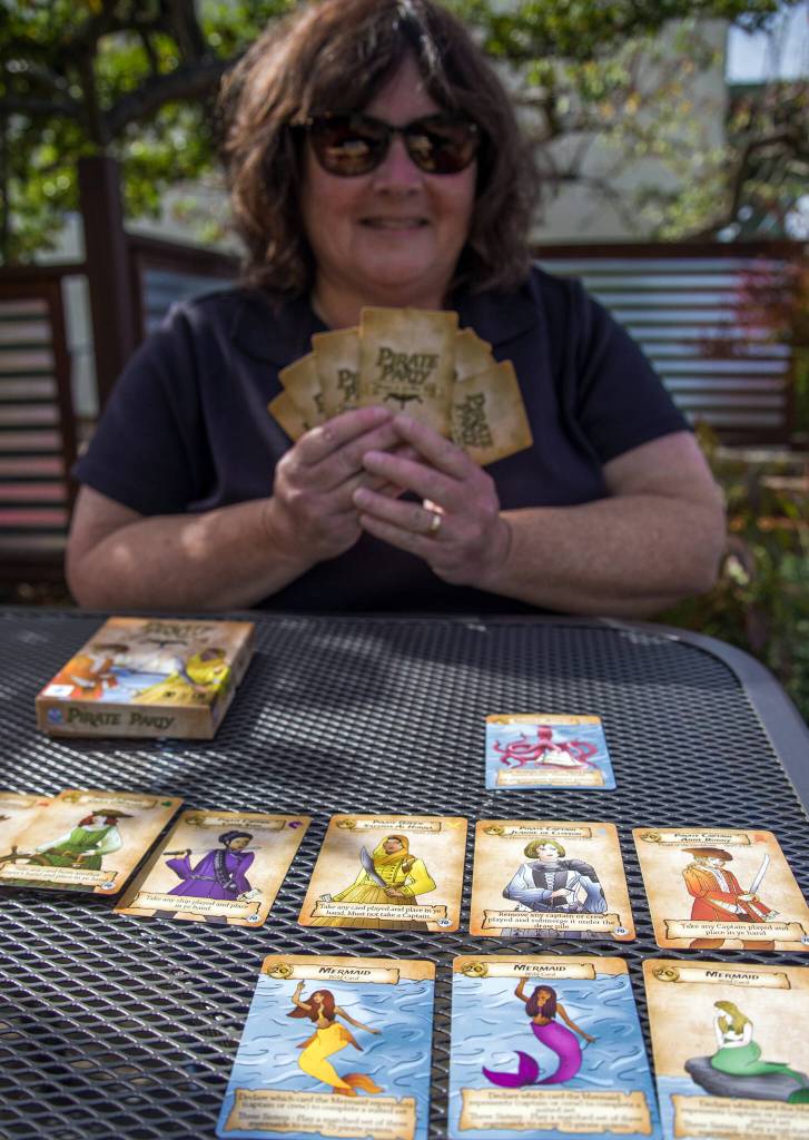 Marge Rosen of Port Angeles demonstrates her game, Pirate Party: Women of the High Seas, at Rainshadow Cafe in Sequim. Sequim Gazette photo by Emily Matthiessen