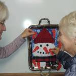 Dungeness Valley Lutheran Church crafters Mary Ann Dangman, left, and Dorothy Smallbeck try out a childrens game created by Dangman for the churchs Nov. 20 Yuletide Bazaar. Submitted photo