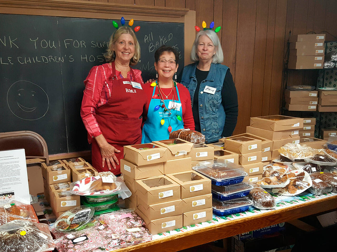 Guild members (from left) Robbie Justyn, Renee Jones and Elaine OBrien help customers at the bake table at the Sequim Guild of Seattle Childrens Hospitals annual bazaar in 2019. Submitted photo