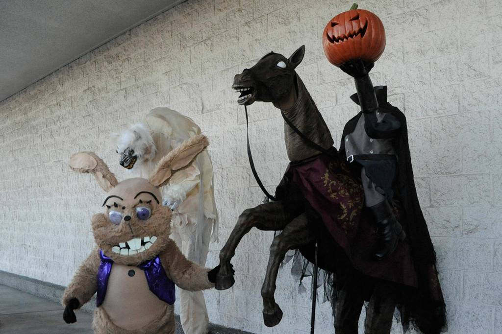 Jaxon Wessel, 8, shakes hooves with a headless horseman animatronic in front of the former JCPenney store on Halloween at the Olympic Peninsula Rat Racers Trunk-or-Treat. Wessels costume of Glitchtrap from the video game Five Nights at Freddys was made by his mom Brandy. Sequims Robert Strausbaugh brought a few of animatronics for the event, too. Sequim Gazette photo by Matthew Nash