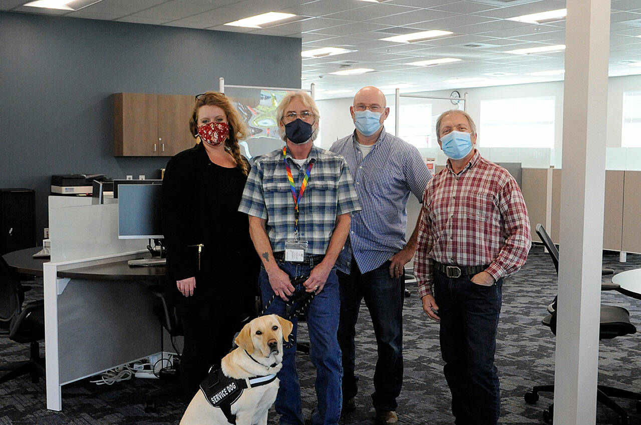 Some of the staff at WorkSource Clallam County stand in the resource lab where locals can soon work on resumes, send emails and more as they seek new work. Pictured staff, include, from left, Claire Weaver, trade act, WIOA adult and dislocated worker for Clallam, Jefferson and Kitsap counties; Jon Ferguson, veterans employment specialist, with 
Professor the dog; John Krouse, strategies for success instructor; and Brandino Gibson, supervisor.