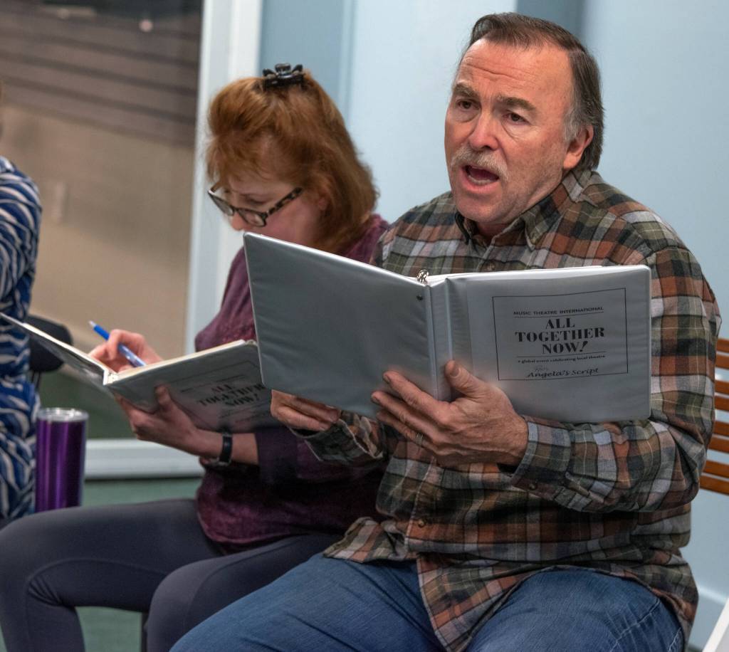 Ron Graham belts out a tune about a dream during a Ghostlight Productions rehearsal for an upcoming livestream fundraising performance. Behind him, Angela Poynter checks her binder. Sequim Gazette photo by Emily Matthiessen