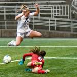 Peninsula Colleges Kyrsten McGuffey hurdles Columbia Basin goalkeeper RiaJo Schwartz during the first half of the Pirates 2-1 come-from-behind win over the Hawks in the NWAC Semifinals on Nov. 12 at Starfire Sports Stadium. Photo by Jay Cline/Peninsula College