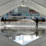 Shawn Kidwell, an employee of Ice-America, a California-based company that rents portable ice rinks, applies water on Tuesday to the refrigerated surface of a temporary rink that will be the highlight of the Port Angeles Winter Ice Village. (Keith Thorpe/Peninsula Daily News)