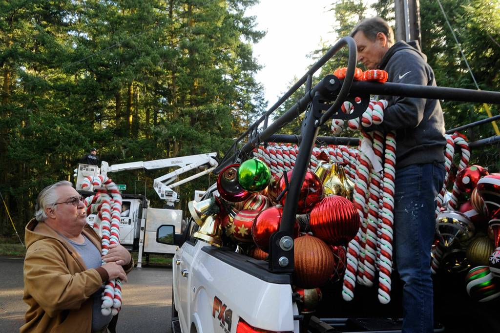 Diamond Point residents Kent Bohac, left, and Craig Tenhoff ready candy canes and ornaments for trees along Diamond Point Road. Sequim Gazette photos by Matthew Nash