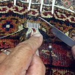 Mohammad Amin Rahmati, owner of Oriental Rug Care, started to learn from his father how to repair rugs at age 13 and almost 60 years later he continues the tradition in his Sequim shop. Here he intricately repairs a rug to make it appear as if no damage had been done. Photo courtesy of the Rahmati family
