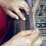 Mohammad Amin Rahmati, owner of Oriental Rug Care, started to learn from his father how to repair rugs at age 13 and almost 60 years later he continues the tradition in his Sequim shop. Here he intricately repairs a rug to make it appear as if no damage had been done. Photo courtesy of the Rahmati family