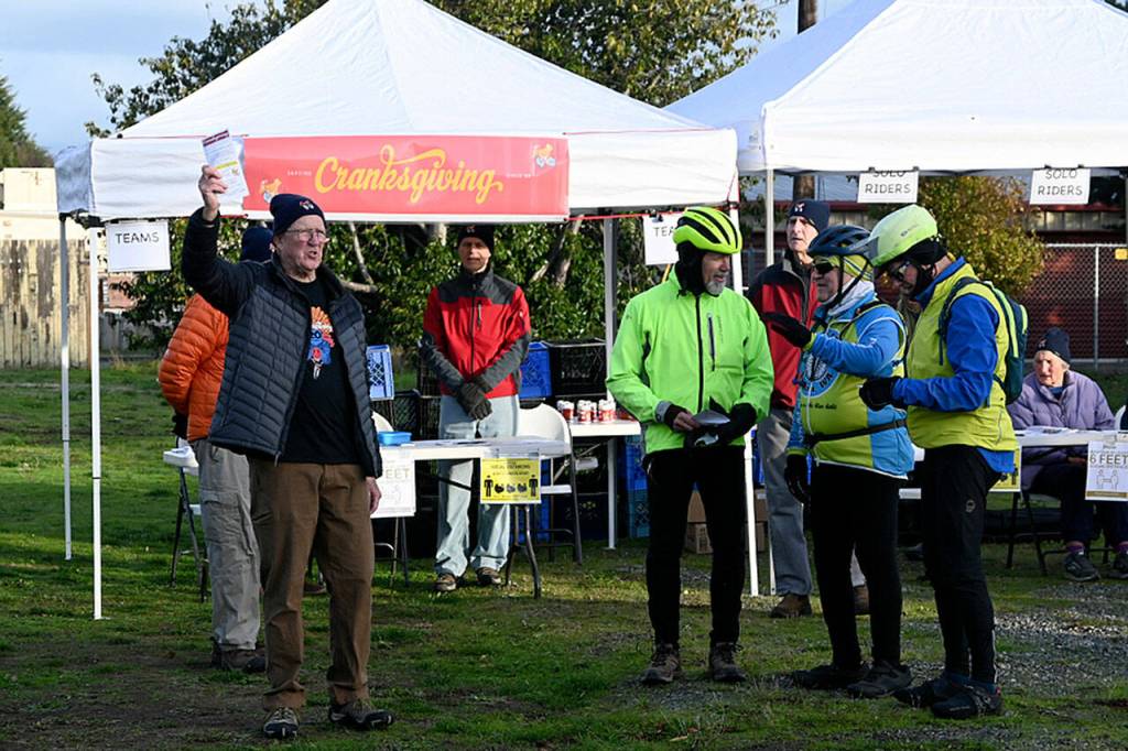 Sequim Cranksgiving organizer Tom Coonelly issues instructions just before the start of the event on Nov. 20, one that annually gathers food and funds for the Sequim Food Bank. Sequim gazette photo by Michael Dashiell
