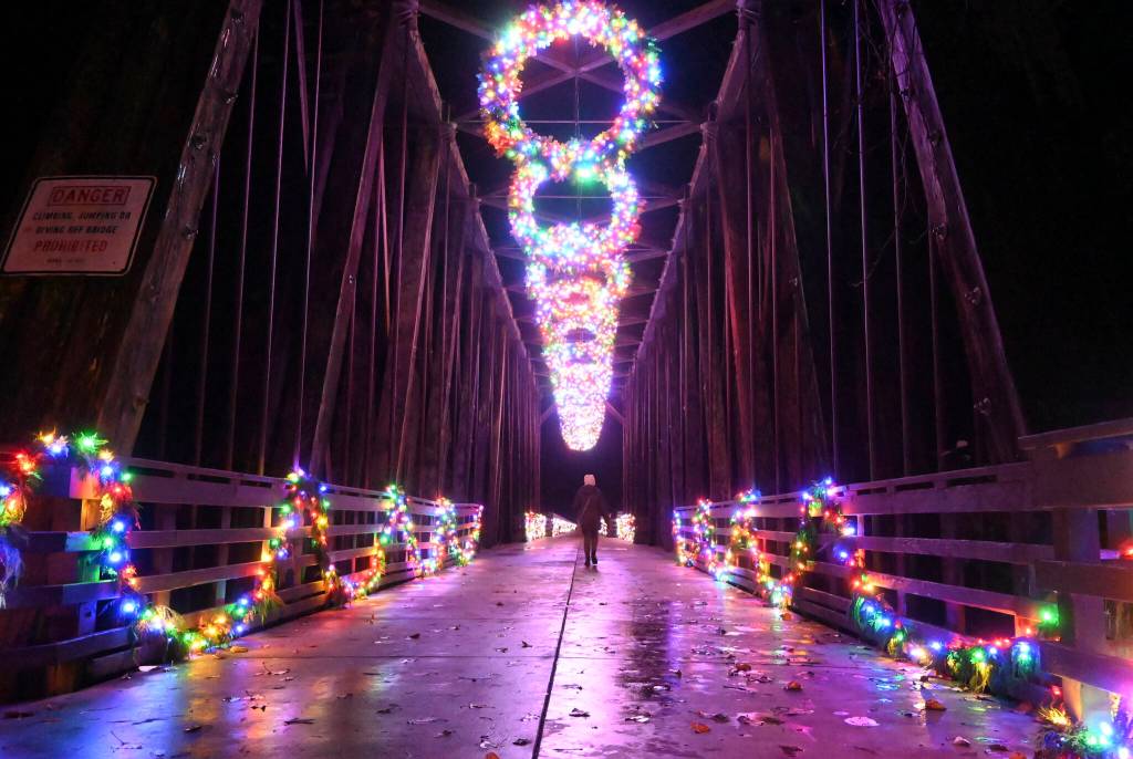 Visitors to Railroad Bridge Park enjoy the colorfully-lit historic bridge earlier this week. Its part of a collective light display by the Jamestown SKlallam Tribe to place 3.25 million lights around the Blyn/Dungeness/ Sequim area. Sequim Gazette photo by Michael Dashiell