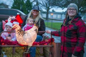 Members of the Bekkevar family smile by their float as they wait to participate in the tractor parade at Sequims Home Town Holidays. Sequim Gazette photo by Emily Matthiessen