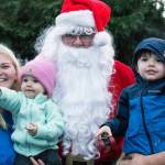 Santa and the Hamilton family spot a tractor on its way to Sequim High Schools parking lot. The Hamiltons were lucky because they were headed south on Sequim Avenue just as Santa headed north after a few hours of greeting people at Centennial Place during Home Town Holidays. Sequim Gazette photo by Emily Matthiessen