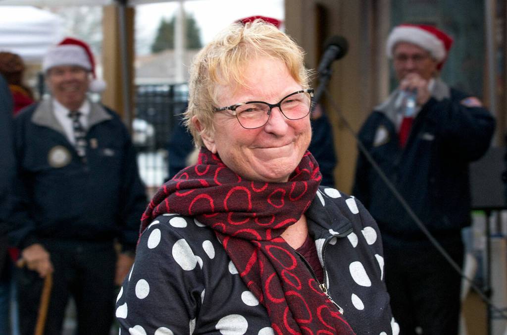 Author Heidi Hansen beams after receiving a round of Happy Birthday from the crowd led my members of the Olympic Peninsula Mens Chorus at Home Town Holidays in downtown Sequim. Sequim Gazette photo by Emily Matthiessen