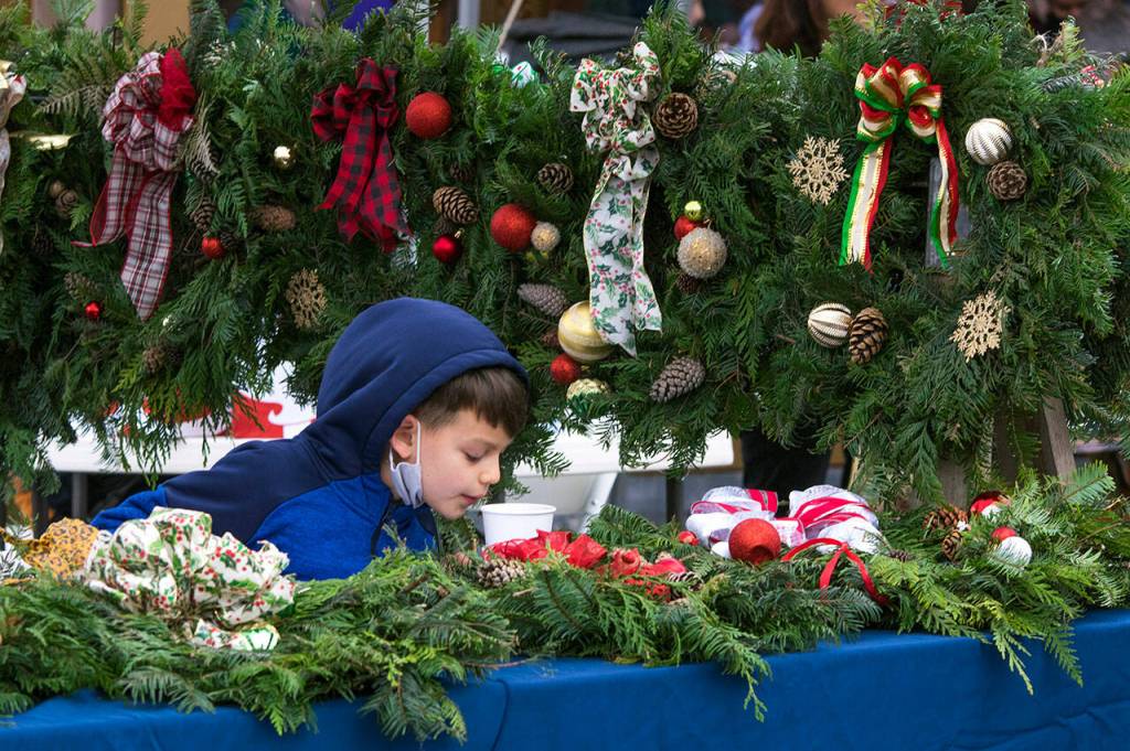Hudson Larrymore, age 7, enjoys a hot drink while manning the cub scout wreath booth at Home Town holidays with his sister Alyssa. By the end of the event few wreaths remained. Sequim Gazette photo by Emily Matthiessen