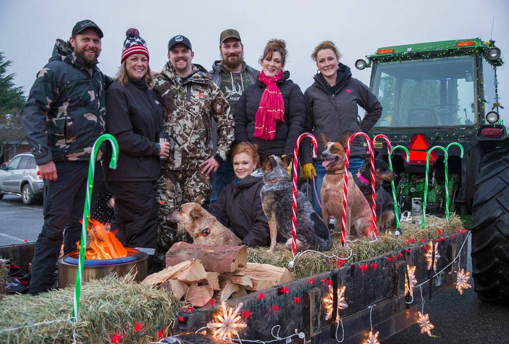The Jaymar Hay and Cattle Company had a large float behind their tractor in the Hometown Holidays tractor parade  large enough to hold at least seven people and four dogs, straw, wood and a fire for warmth in the drizzle that greeted those who participated in this usually annual Sequim event. Sequim Gazette photo by Emily Matthiessen