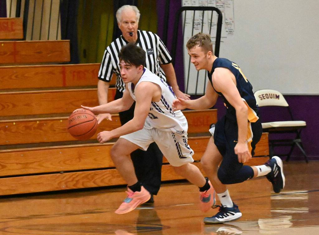 Sequim senior guard Jayden Possin, left, tries to sprint past Forks Logan Olson in the Wolves 65-45 win on Dec. 3. Sequim Gazette photo by Michael Dashiell
