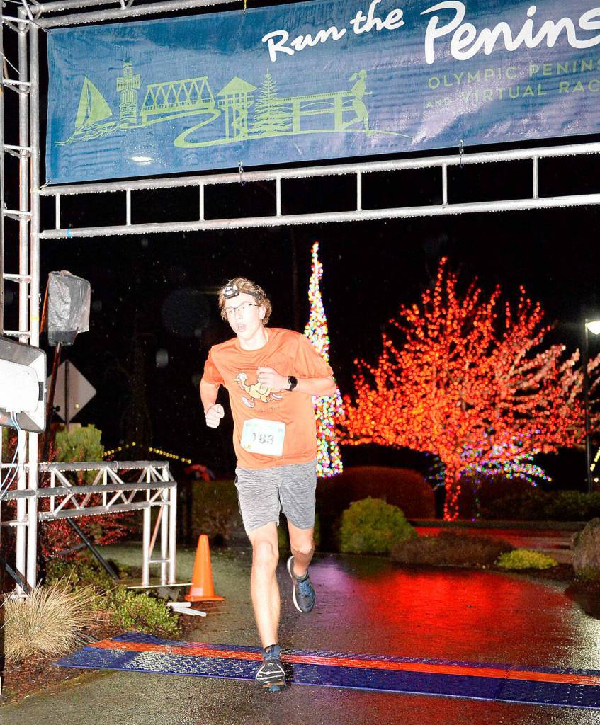 Sequim teen Colby Ellefson crosses the finish line first in the Jamestown SKlallam Glow Run 5k race on Dec. 4. Photo courtesy of Run the Peninsula