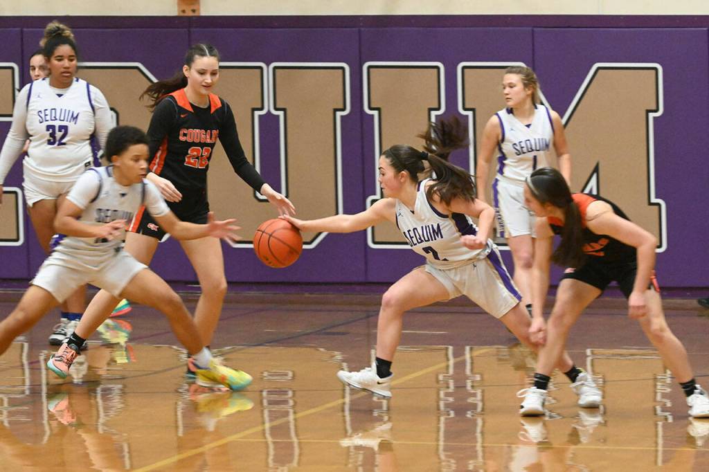 Sequims Bobbie Mixon, let and Hannah Bates steal the ball in the Wolves Dec. 13 non-league home match-up with Central Kitsap. The visiting Cougars beat Sequim, 44-42. Sequim Gazette photo by Michael Dashiell