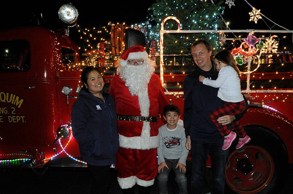 The Smith family stops to drop off items for the Santa Brigade on Dec. 9 and take a family photo, with, from left, mom May, Santa Claus, Brayden, 6, dad Ryan, and Alyx, 3. Sequim Gazette photo by Matthew Nash