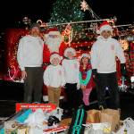 Santa Brigade crew members, from left, Marc Lawson, Santa Claus (John Brygider), Parker Horst, Connor Horst, Isabel Lawson, and Len Horst gather at the end of three days of gathering goods for Toys for Sequim Kids. Sequim Gazette photo by Matthew Nash