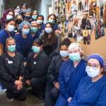 Some of the 27 member staff at Northwest Eye Surgeons pose by a bulletin board full of images from good times with Dr. Matthew Niemeyer. Sequim Gazette photo by Emily Matthiessen