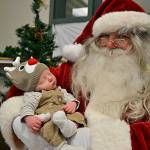 Santa Claus, aka George Stuber, holds a newborn baby at the Breakfast with Santa event in 2014. Sequim Gazette photo by Matthew Nash