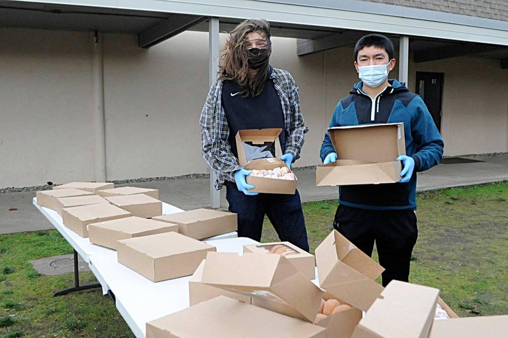 Richard Meier and Koda Robinson ready to hand out doughnuts for Winter Wishes. Sequim Gazette photo by Matthew Nash