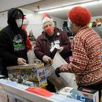 Sequim Community Aid volunteers Jean deJong and Pat Gritman help Ken Glen find the right toys for his four children at Toys for Sequim Kids on Dec. 15. Sequim Gazette photo by Matthew Nash