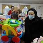 Alisha Whitley looks through the family movies at Toys for Sequim Kids on Dec. 15 with her helper elf Linda Reichl. Sequim Gazette photo by Matthew Nash