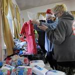 Kathy Joyner, co-organizer of Toys for Sequim Kids, helps Jean Ann Houk size up a t-shirt for one of her children this Christmas. Sequim Gazette photo by Matthew Nash