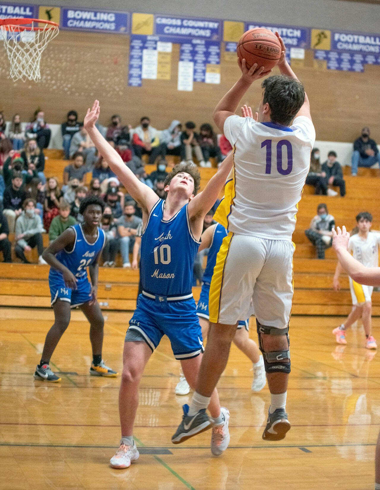 Top: Sequims Isaiah Moore, right, drives in for a basket in the Wolves 61-50 win over North Mason on Dec. 16. Moore and Keenan Green led the team with 15 points apiece. Bottom: Sequims Pryce Glasser, right, puts up a shot over North Masons Nick Minaker. Sequim Gazette photos by Emily Matthiessen