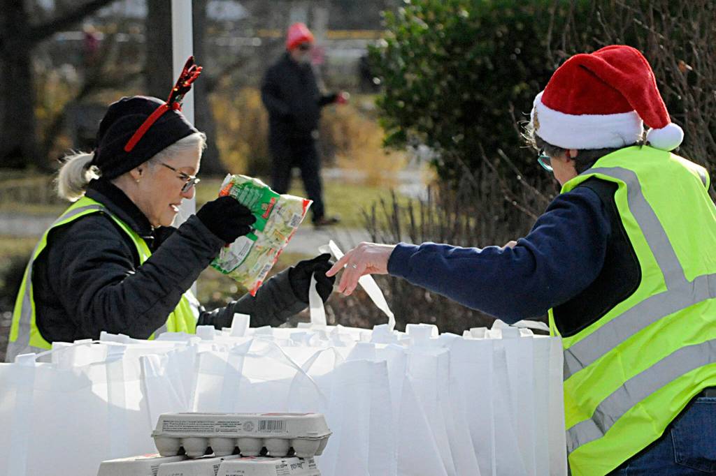 Becky Roberts, left, and Ann Flack, president of the Sequim Sunrise Rotary, fill bags for Decembers Family Holiday Meal Bag program. The Rotarians were one of many groups participating in the even on Dec. 17. Sequim Gazette photo by Matthew Nash