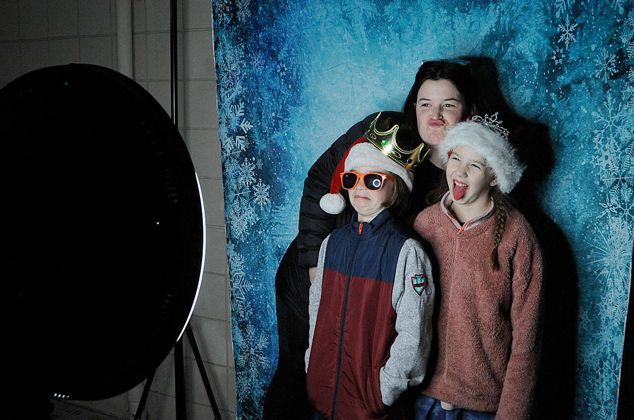 With lights and music throughout the courtyard, Helen Haller Elementarys Parent Teacher Organization hosted a Winter Wonderland on Dec. 16 with lights, popcorn, music, hot cocoa, a photo booth and an appearance by Santa Claus. Here, Samantha Rossi takes a selfie with her daughters Olive and Elliana. Sequim Gazette photo by Matthew Nash
