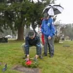 Third mate Russel Hammond, left, and Second Mate Bob Barbee, representing the U.S. Merchant Marines, lay a wreath on the grave marker of fellow Merchant Marine Olen Oral Brown at Sequim View Cemetery on Dec. 18.