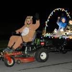 Left: The Castell family  James, Bennett, Grayson and Sarah  ride through Sunland sharing the Christmas spirit to small crowds for Southern View Estates annual lawnmower parade. Above: Gary and Sylvia Stanton ride through Sunland on their A Christmas Story float. Sequim Gazette photos by Matthew Nash