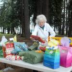 Ingrid Carmean of Port Angeles, a member of Food Not Bombs, an international group dedicated to assisting and feeding homeless individuals, sets up a table filled with Christmas presents on Dec. 25 at Jesse Webster Park in Port Angeles. The presents, along with a hot lunch, were distributed to needy individuals on Christmas Day, one of the groups every-other-weekend community meals. Photo by Keith Thorpe/Olympic Peninsula News Group