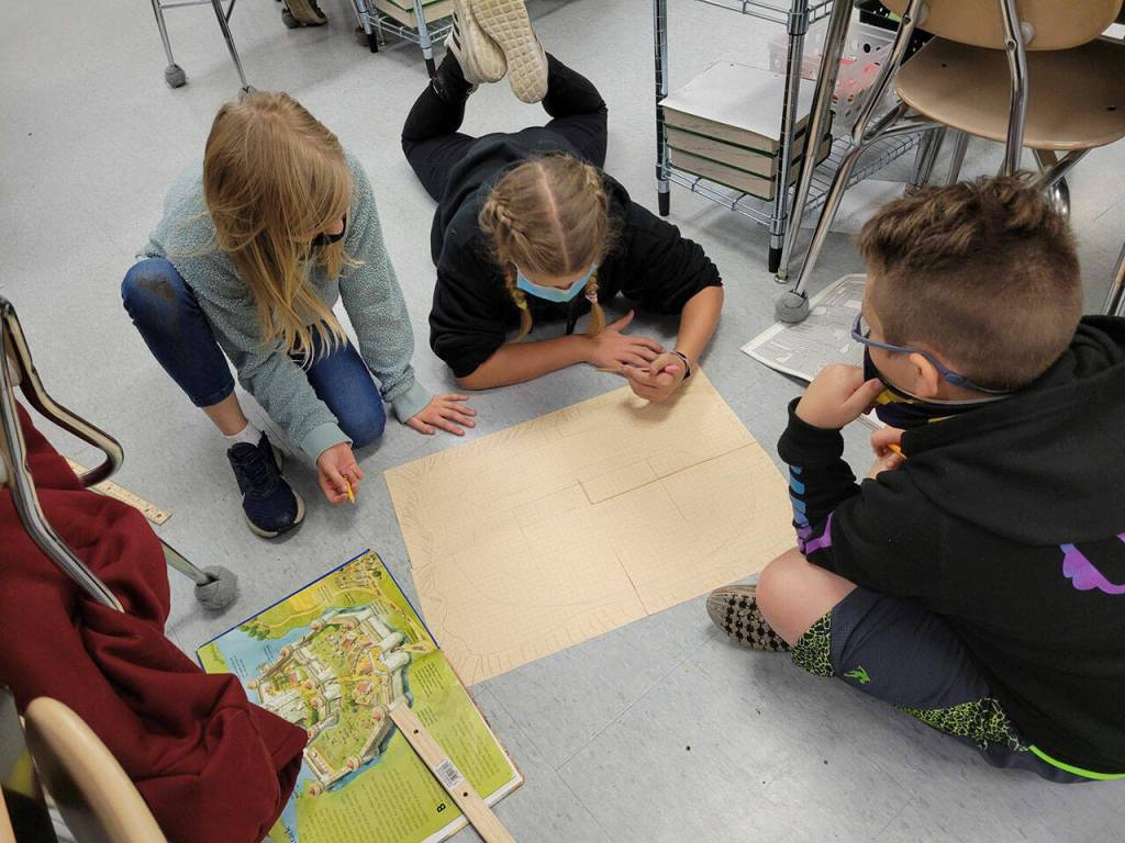 From left, Lila Nix, Anella Henning and Olyver Van Selus, fifth-graders in Saxon Holt's class at Helen Haller Elementary School, draw schematics on a medieval castle. Submitted photo