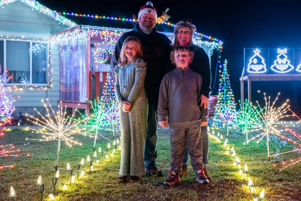 in December, the Bixby family, Emma, Corey, Tennille and Colin stand in their yard which they have decorated with Christmas lights that are programmed to change with music. Sequim Gazette photo by Emily Matthiessen