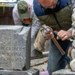Using a chisel and hammer, Chris Smith chips away white mortar from the headstone of the infant son of R. and Eleanor Irwin at Pioneer Memorial Park in October. "God for him his angels sent," can be read. George Caskedy's headstone was cleaned and reset in the corner of Pioneer Memorial Park along with a collection of other headstones from the late 1800s to the early 1900s by volunteers. Sequim Gazette photo by Emily Matthiessen