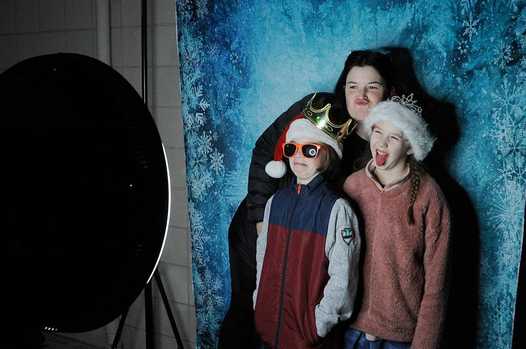 With lights and music throughout the courtyard, Helen Haller Elementarys Parent Teacher Organization hosted a Winter Wonderland on Dec. 16 with lights, popcorn, music, hot cocoa, a photo booth and an appearance by Santa Claus. Here, Samantha Rossi takes a selfie with her daughters Olive and Elliana. Sequim Gazette photo by Matthew Nash