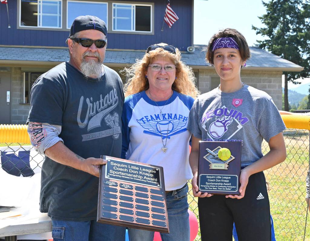 Sequim Little League softballer Mia Kirner, right, accepts the Don Knapp Sportsmanship Award from Tony and Brenda Knapp Bistline on July 10 at the leagues season-ending ceremonies. In part to honor the legacy of longtime volunteer/advocate Don Knapp, who passed away in November 2020, the league created the sportsmanship award for one baseball player and one softball player. Kirner and baseballer Bryant Laboy (who received the award at a separate ceremony) are the first recipients. Sequim Gazette photo by Michael Dashiell