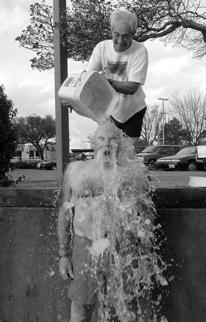 Bruce Monro of Port Angeles reacts to the shock of having a bucket of ice water poured on him by Dan Welden of Port Angeles at the conclusion of the annual Polar Bear plunge on New Years Day at Port Angeles Hollywood Beach. Although there was no organized plunge due to COVID-19 restrictions, many people showed up anyway to run into the chilly water of Port Angeles Harbor. Photo by Keith Thorpe/Olympic Peninsula News Group