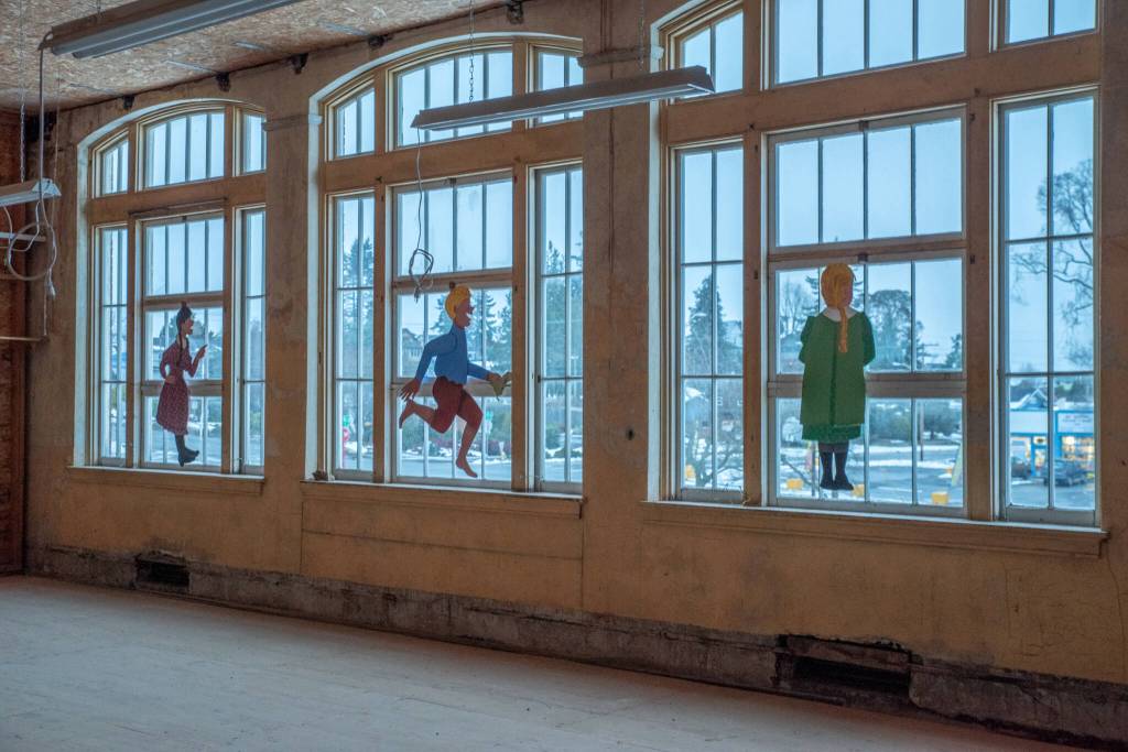 Paintings of children by Port Townsend artist Pat Gallup are frozen in perpetual childhood on the windows of the old Lincoln School in Port Angeles, which closed in 1978 and was bought by the North Olympic History Center in 1991. Sequim Gazette photo by Emily Matthiessen