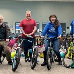 Sam Chandler, owner of Bens Bikes, and Mary Budke, executive director of the Boys & Girls Clubs of the Olympic Peninsula, sit on some new bikes Chandler donated for in-need club members in Sequim and Port Angeles. Tessa Jackson, Sequims unit director, and Heath Baker, Sequims program director, in back row, said students will submit requests and staff will assess need. Sequim Gazette photo by Matthew Nash
